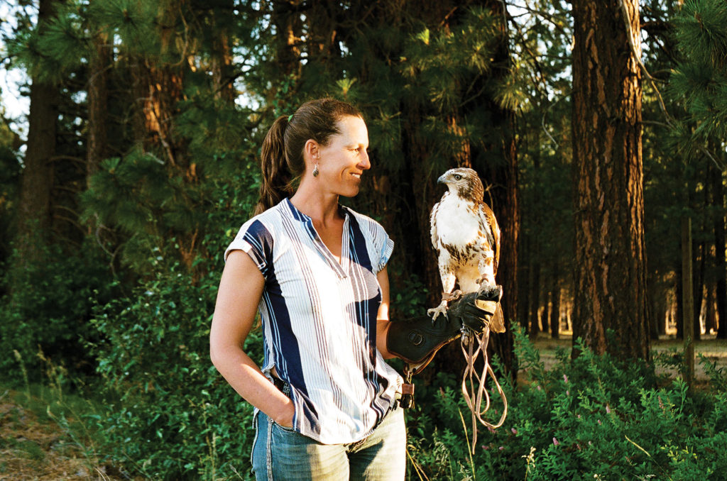 Saralee Lawrence stands with falcon in hand