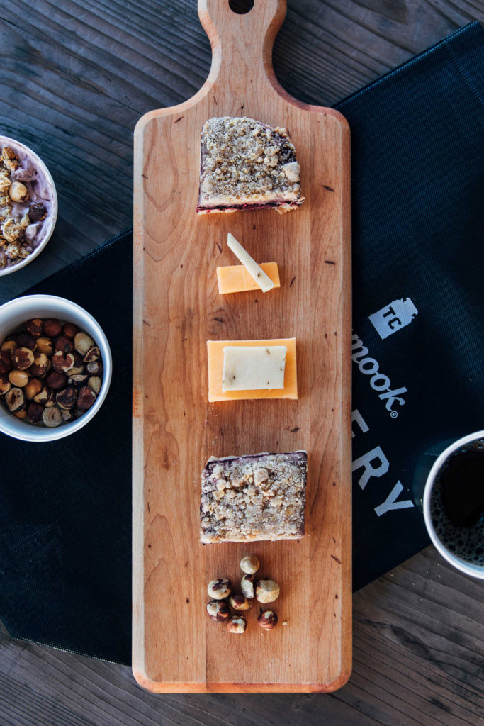 A variety of cheeses laid out on a wooden serving tray—provided by the cafe in Jacobsen Salt Co. visitor center.