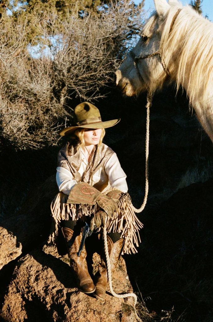 Cate Havstad sitting alongside of her horse.