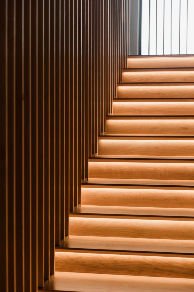 Wooden stairs that are brightly lit on each step.