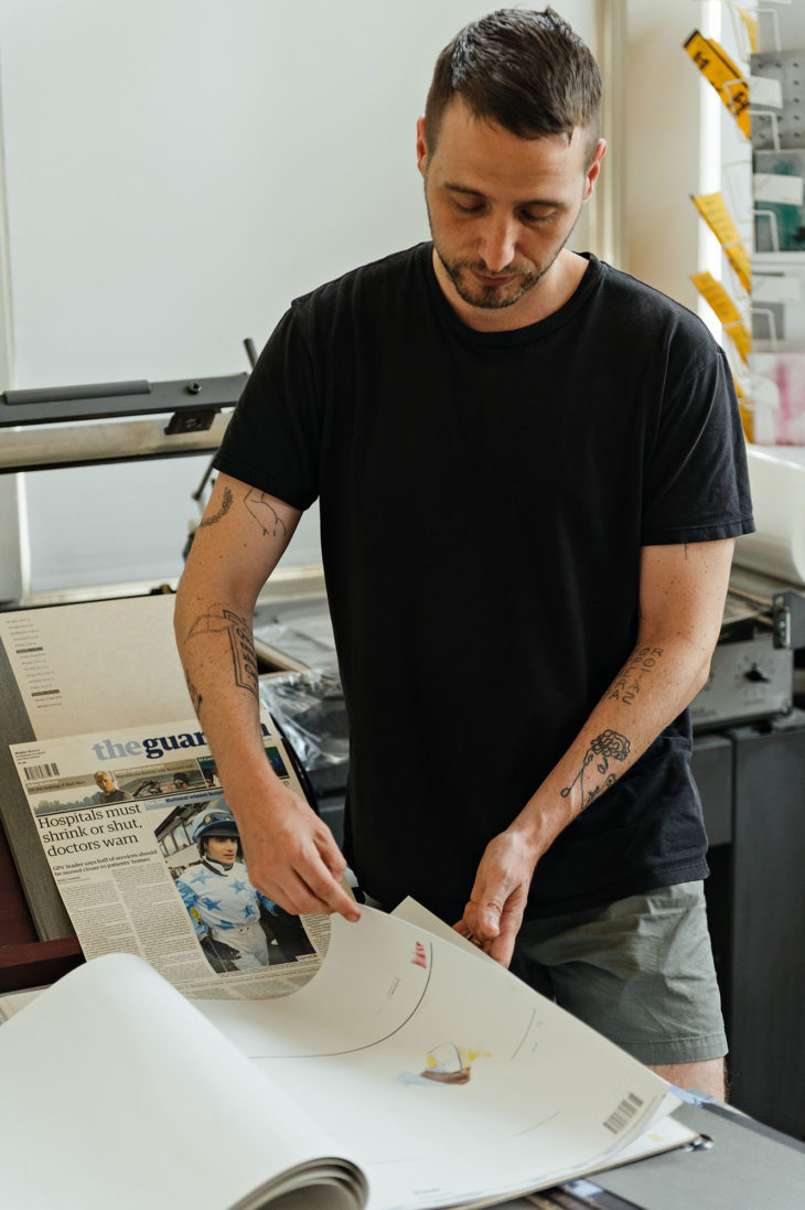Male is black shirt flipping through large papers