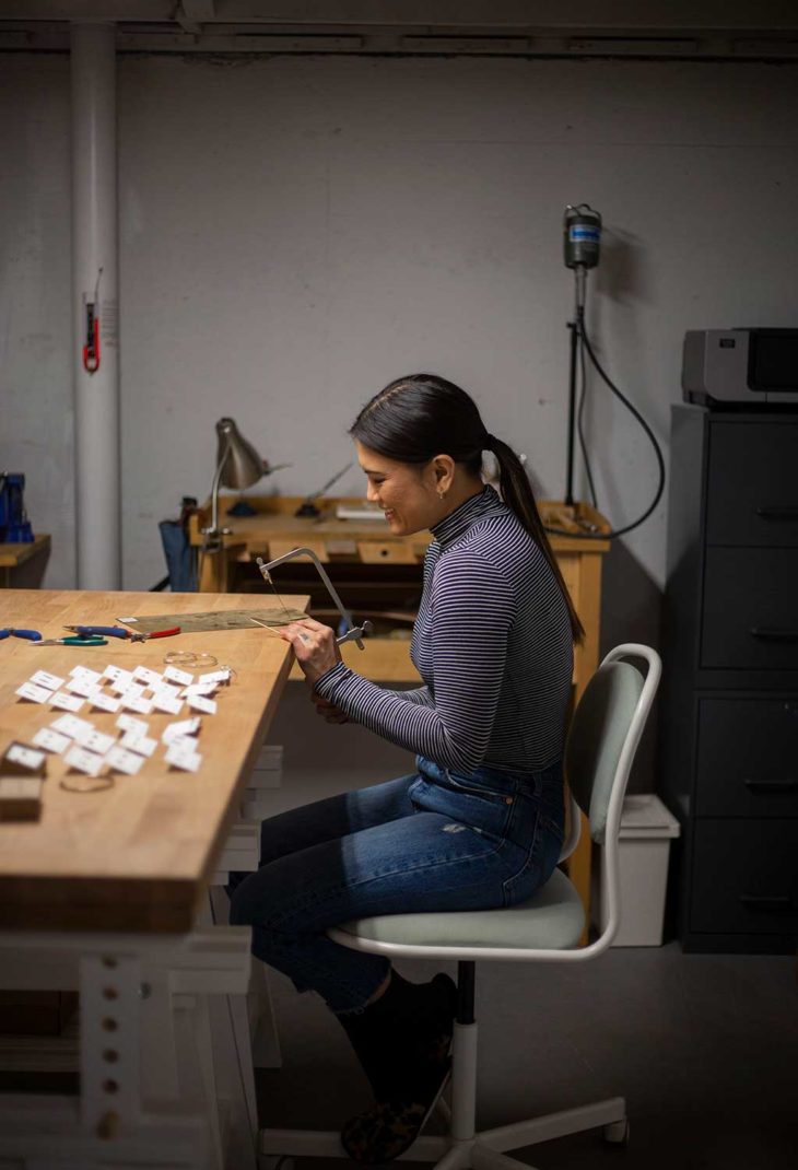 A woman working on jewelry in a workshop