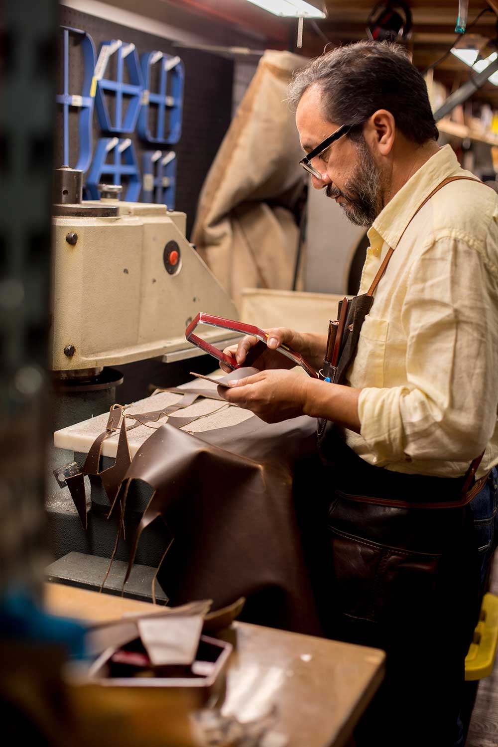 A man working with pieces of leather in a workshop