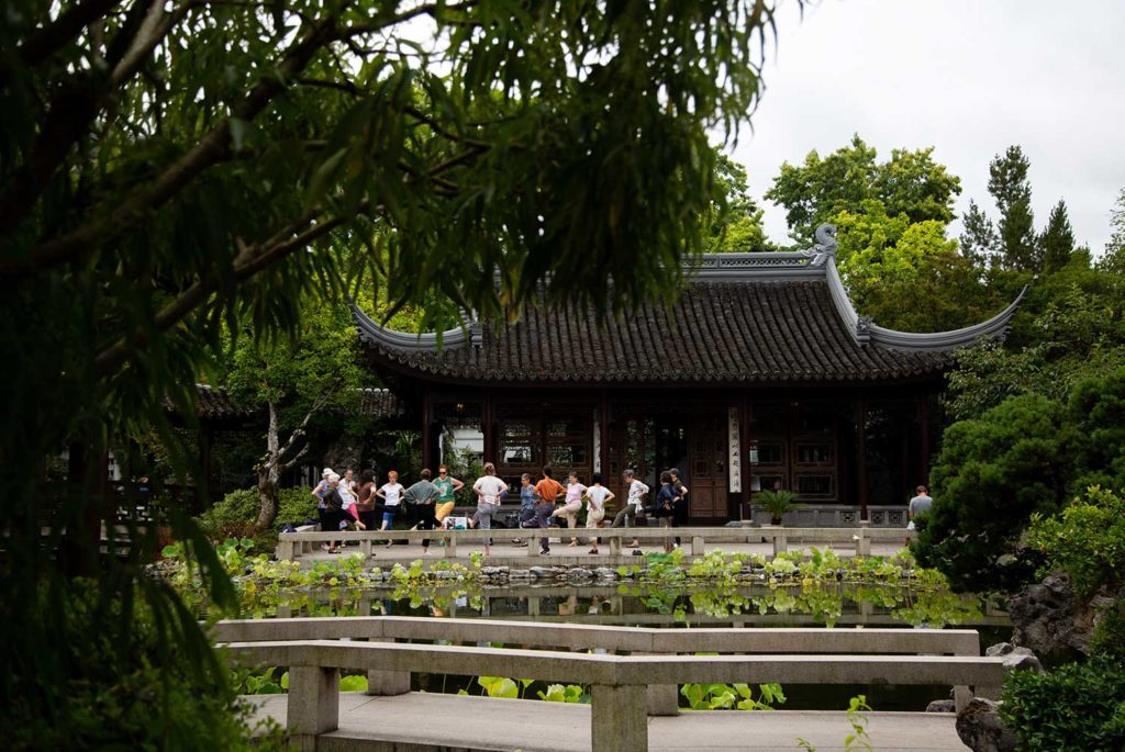 A line of people waiting outside of a Chinese teahouse